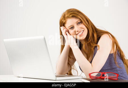 Pretty redhead lavorando sul computer portatile Foto Stock