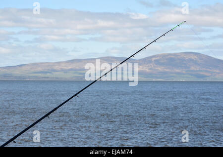 Canna da pesca al molo di Silloth, Il Solway Firth. Attraverso il modo in cui sono le colline del sud Galloway Foto Stock