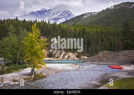 Barche rosso di un kayak sul fiume costa Foto Stock