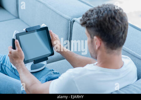 La mezza età uomo utilizzando Cool Tablet al lettino Foto Stock