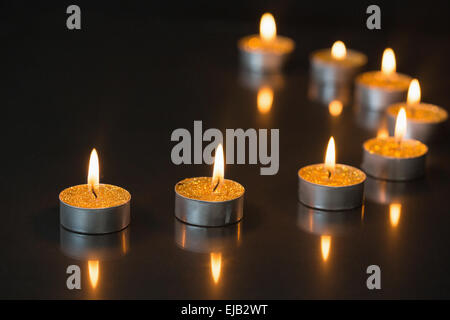 Otto piccole candele accese Foto Stock