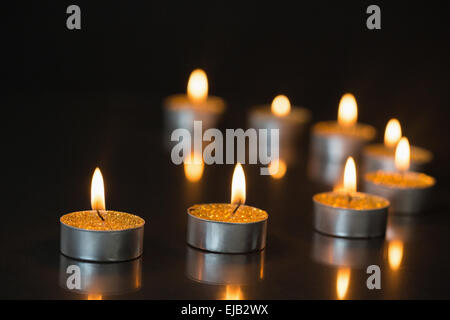 Otto piccole candele accese Foto Stock