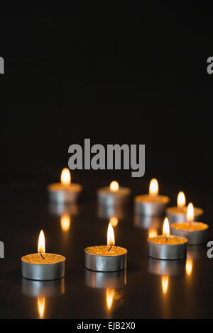 Otto piccole candele accese Foto Stock