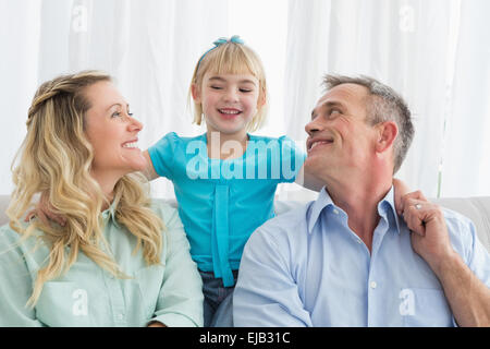 La famiglia felice rilassante sul lettino Foto Stock