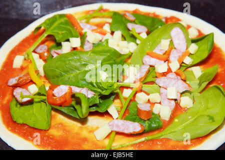 Materie pizza con spinaci e salsa di pomodoro Foto Stock