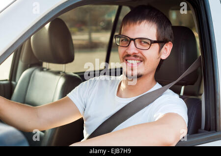 Europei maschili buon conducente è sempre sorridente in suo automobile Foto Stock