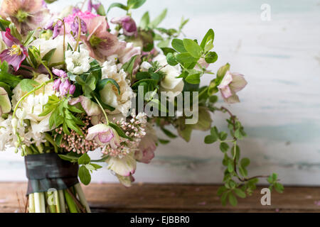 Abbondanti bouquet floreale di primavera in fiore tra cui l'elleboro ranunculus parrot tulip tulipa e bianco Cuore di spurgo Foto Stock