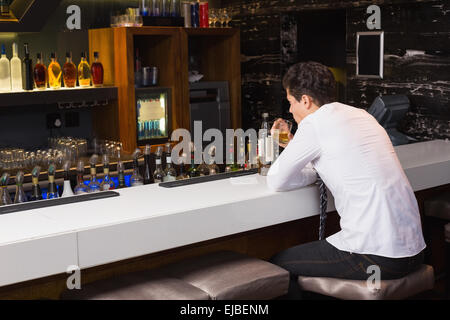 Giovane uomo di bere whisky neat Foto Stock