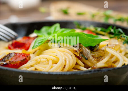 Gli spaghetti cotti al forno con pomodorini e basilico Foto Stock