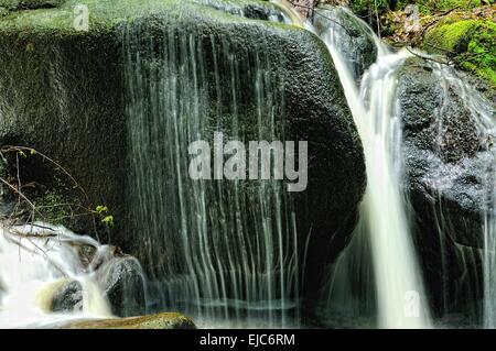 Acqua oltre il disco pietra in granito Foto Stock