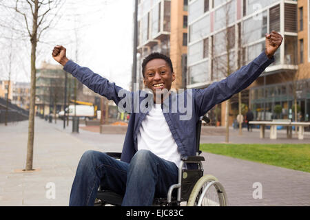 Felice utente di sedia a rotelle per celebrare un successo. Foto Stock