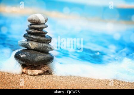 Piramide di pietre sulla sabbia che simboleggia lo zen Foto Stock