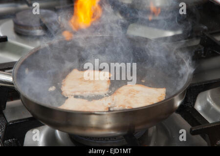 Friggere la carne in una padella Foto Stock