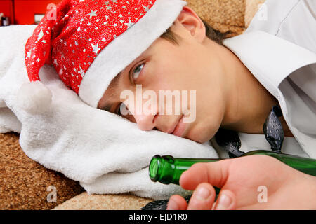 Drunken adolescente in Santa Hat Foto Stock