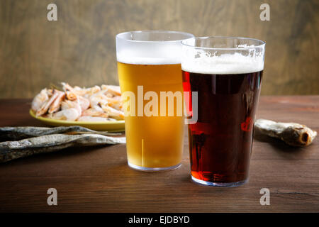 Due bicchieri di birra con pesci secchi e gamberi di fiume Foto Stock