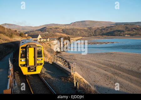 Votato come uno dei più scenografici viaggi ferroviari in U.K.questo treno costiero linea per Barmouth attraversa il ponte sul fiume Mawddach/estuario Foto Stock