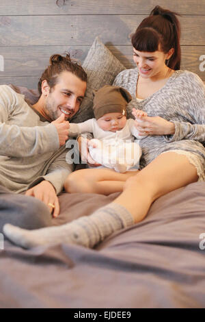 Un padre, madre e bambino piccolo gioca in casa. Foto Stock