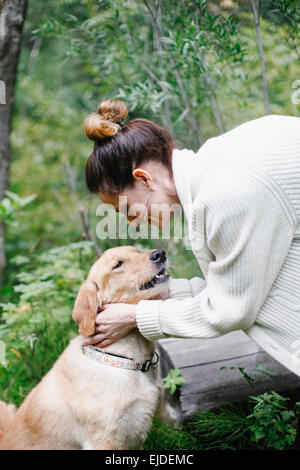 Una donna come accarezzare il suo cane. Foto Stock