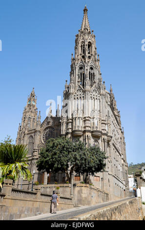 Un anziano uomo cammina passato il neo-gotica chiesa parrocchiale di San Juan Bautista, Arucas, Gran Canaria Isole Canarie Spagna Foto Stock