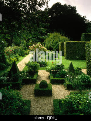 Topiaria da casella sulla zona di ghiaia nel paese grande giardino in estate con alte siepi tagliate Foto Stock