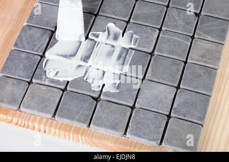 Lavoratore si applica boiacca a piastrelle grigie Foto Stock