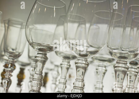 Alcune righe vuote di bicchieri di vino su sfondo bianco. Primo piano Foto Stock