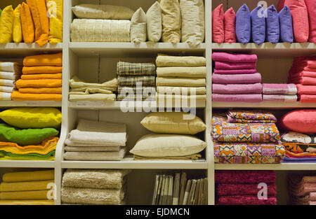 I cuscini erano luminosi, asciugamani, Plaid, coperte e altri home usura sui ripiani Foto Stock