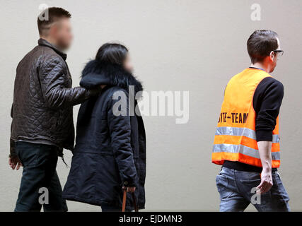 Dusseldorf, Germania. 24 Mar, 2015. Un dipendente dell'aeroporto passeggiate con i parenti dei passeggeri del si è schiantato un aeromobile di tipo Airbus A320 azionato dal bilancio tedesco " Compagnia aerea Germanwings' attraverso l'aeroporto di Duesseldorf, Germania, 24 marzo 2015. Germanwings volo 4U 9525 da Barcellona a Duesseldorf si schiantò vicino a Barcelonnette, nel dipartimento delle Alpes-de-Haute-Provence, Francia, con più di 140 passeggeri ed equipaggio sei a bordo, tedesco del controllo del traffico aereo detto 24 marzo 2015. Credito: dpa picture alliance/Alamy Live News Foto Stock