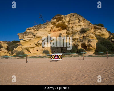 Segnaletica di pericolo di fronte instabile la scogliera alla spiaggia Albufeira, Algarve, Portogallo, Europa Foto Stock