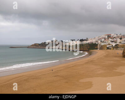 Persona che cammina da sola su una spiaggia deserta di inverno in Albufeira, Algarve, Portogallo, Europa Foto Stock