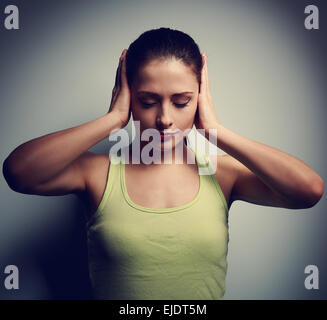 La confusione di pensiero infelice donna con mal di testa su sfondo scuro. Closeup ritratto Foto Stock