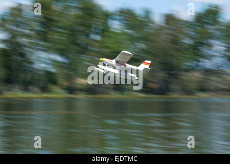 Radio Controlled idrovolante volare sopra il fiume Guadiana superficie, Badajoz, Spagna. L'immagine mostra la sfocatura in movimento Foto Stock