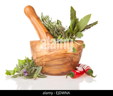 Mortaio di legno riempita con erbe aromatiche fresche, isolato su sfondo bianco Foto Stock