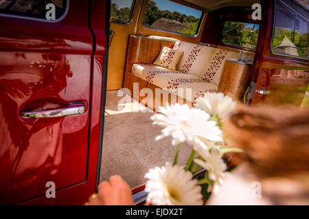 Un rosso brillante VW camper Autobus preparato per un matrimonio. Foto Stock