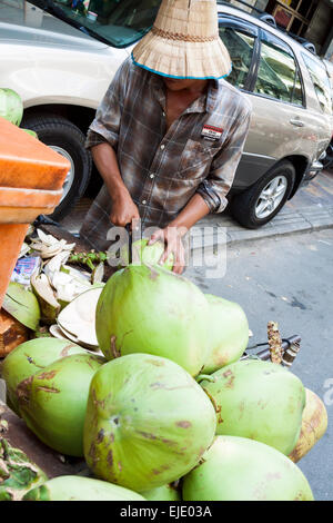 Un venditore ambulante vendita di noci di cocco sulla strada a Phnom Penh in Cambogia, in Asia. Foto Stock