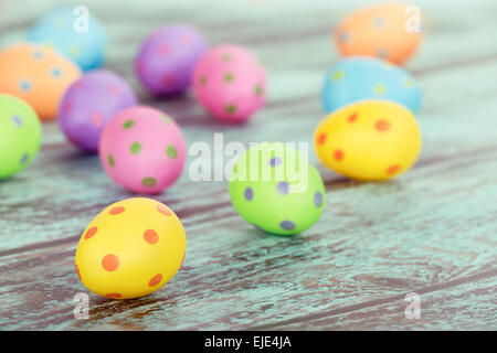 Color pastello le uova di Pasqua su vintage verde sullo sfondo di legno Foto Stock