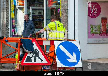 Segni e barriere attorno a operai in Newton Abbot centro città Foto Stock