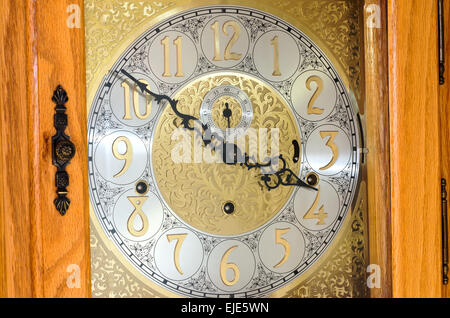 Orologio vintage il viso e le mani di ornati orologio del nonno dietro il vetro e il legno case in legno di quercia Foto Stock