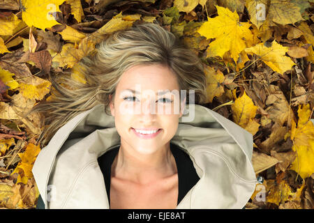 Un autunno donna in studio con foglie di autunno Foto Stock