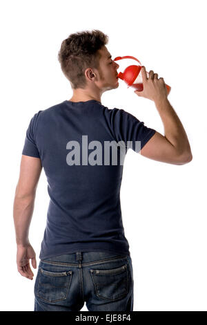 Attraente giovane uomo o ragazzo beve protein shake dalla bottiglia. Isolato su bianco, visto dal retro Foto Stock