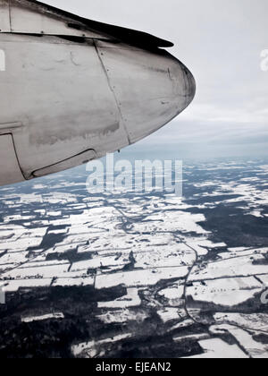 Vista del carrello di atterraggio e ruota di un Bombardier aerei sopra il paesaggio invernale Foto Stock