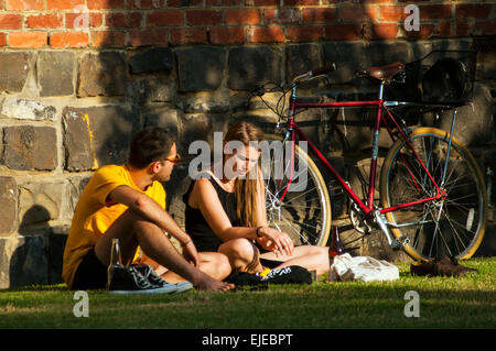 I ciclisti in appoggio di fronte in mattoni e pietra blu edificio, Fitzroy, Victoria, Australia Foto Stock
