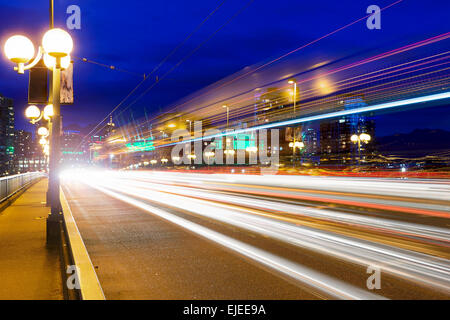 Ora di punta del traffico sentieri di luce sul ponte Cambie a Vancouver British Columbia Canada durante la sera ore blu Foto Stock