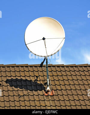 Una parabola satellitare sul tetto di un edificio Foto Stock