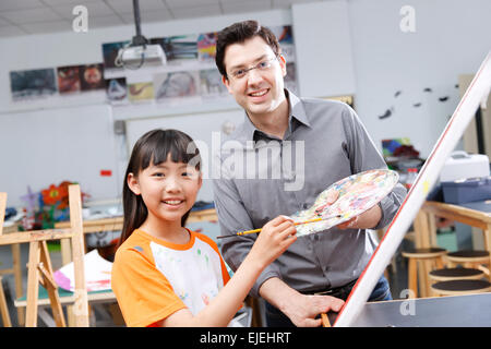 L insegnante e gli studenti nella pittura studio Foto Stock