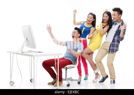 Emozionante giovani guardando i monitor dei computer Foto Stock