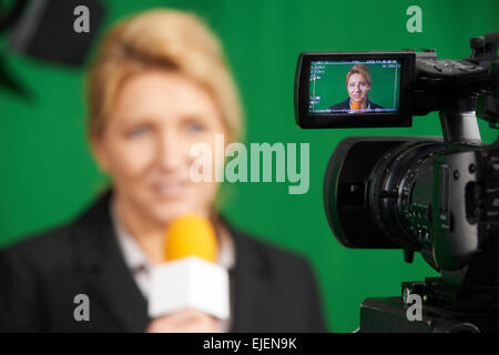 Giornalista femmina presentando Relazione In Studio televisivo Foto Stock
