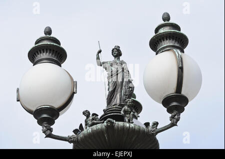 Un vecchio lampione con una femmina permanente di scultura e putti in cima al di fuori del Parlamento austriaco edificio, Vienna, Austria. Foto Stock