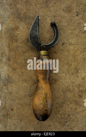 Vintage tin-assolcatore con chunky manico in legno e metallo di spessore lama sulla scheda di antiquariato Foto Stock