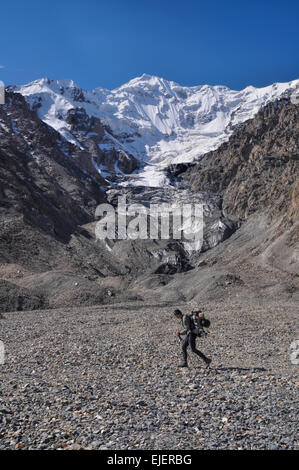 Gli escursionisti a piedi attraverso scenic Engilchek ghiacciaio con la pittoresca piazza Tian Shan mountain range in Kirghizistan Foto Stock